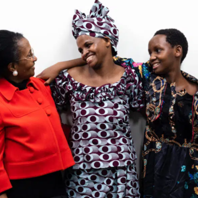 Burundian mother hugging her daughter after years of sepation. They pose together with the local counsellor who helped them reunite
