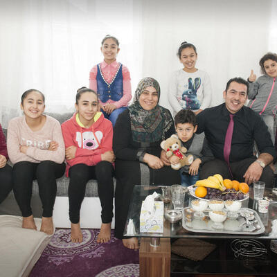 Syrian refugee family posing together in their home in Austria