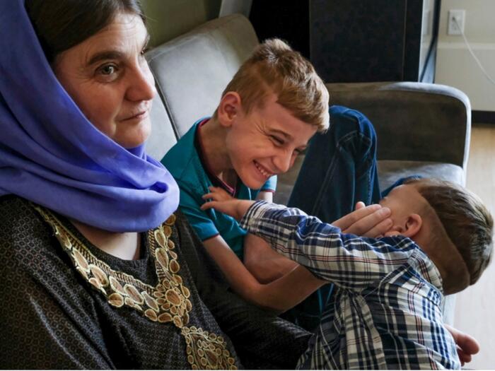 Iraqi boy, Emad, plays with his brother after being reunited with his family in Canada.