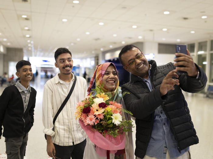 Refugee family taking a selfie photo at their reunification at an airport