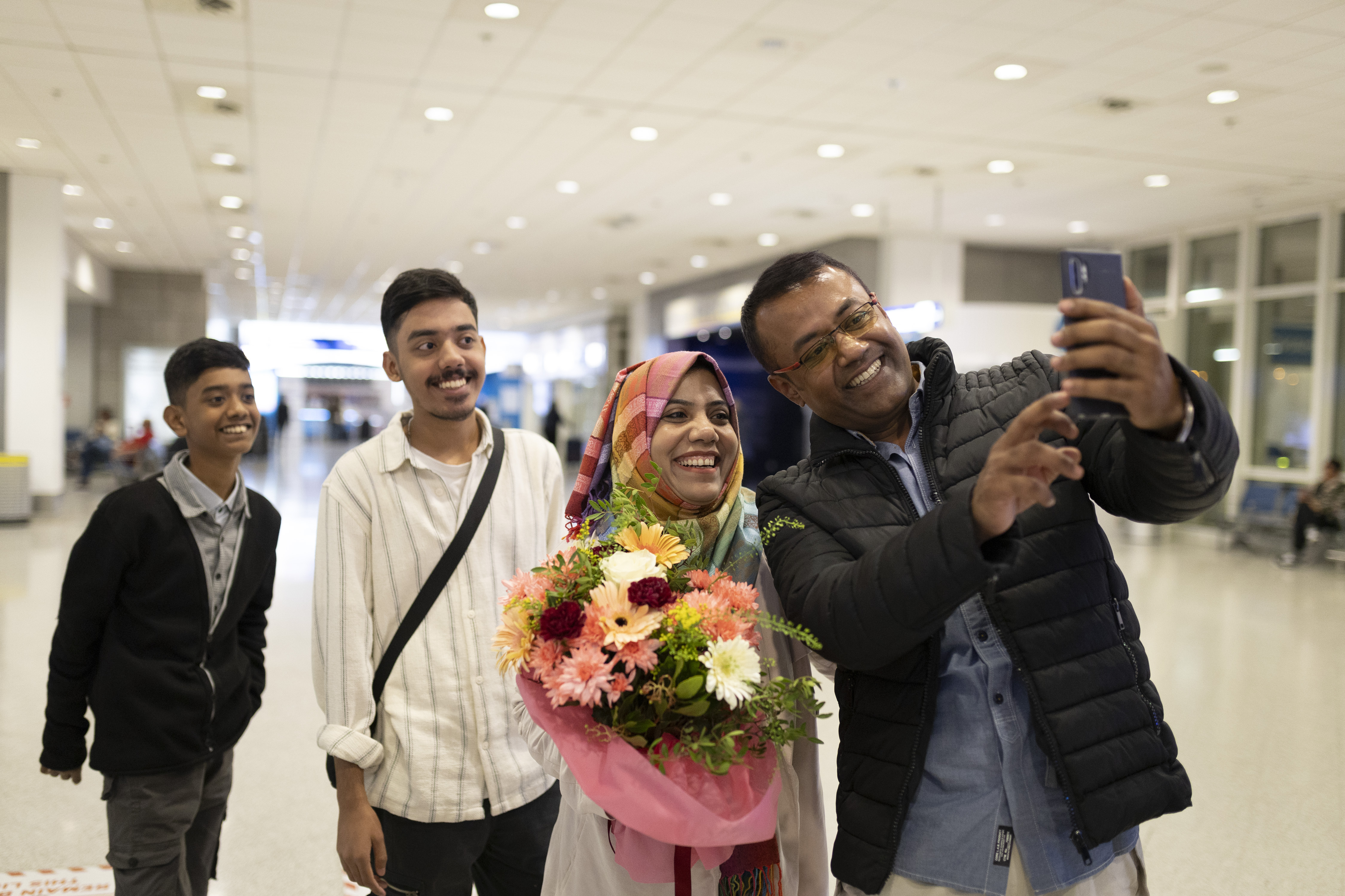 Refugee family taking a selfie photo at their reunification at an airport